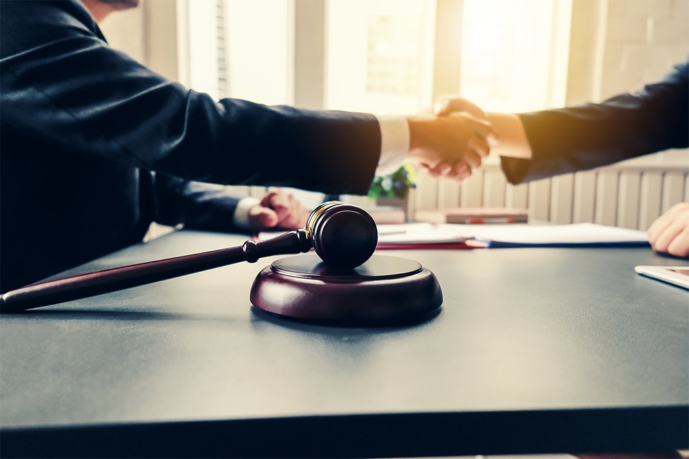 Businessman shaking hands to seal a deal with his partner lawyers or attorneys discussing a contract agreement - Our Services
